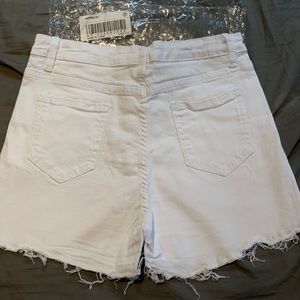 White stretchy jean shorts with fringe